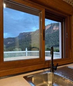 a kitchen sink with a view of the mountains through a window at Villa Ibañez Alto in Villanueva del Arzobispo