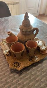 a tea pot and three cups on a table at Charmante maison au calme in Sainte-Maure +15 photos