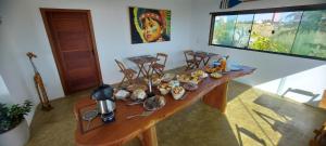 a wooden table with food on it in a room at Pousada Atlantik-Haus in Costa Dourada