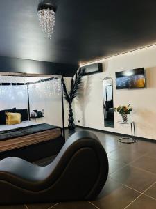 a living room with a couch and a chandelier at Le Bovary Hotel Suite Diamond in Héron