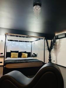 a bedroom with a canopy bed and a chandelier at Le Bovary Hotel Suite Diamond in Héron +14 photos