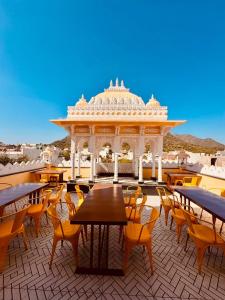 a patio with tables and chairs and a gazebo at Shree ji palace hotel in Udaipur