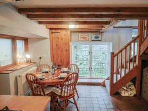 a dining room with a table and chairs and a window at Riverdance Cottage in Lyme Regis