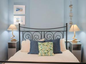 a bedroom with a black bed with two lamps at Riverdance Cottage in Lyme Regis