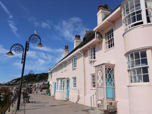 a white building with blue doors and a street light at Riverdance Cottage in Lyme Regis