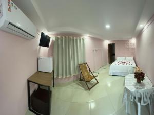 a bedroom with a bed and a table and a table and chair at Pousada coração da serra in Serra de São Bento