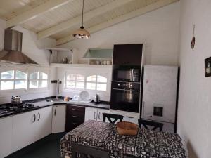 a kitchen with white cabinets and a table in it at blue beach in Rocha