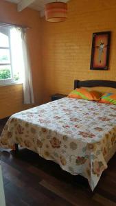a bedroom with a bed with a quilt on it at blue beach in Rocha +7 photos