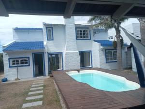 a house with a swimming pool in front of a house at blue beach in Rocha