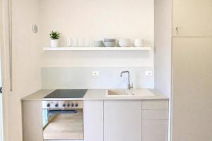 a white kitchen with a sink and a stove at H - Cozy Apartment - Perfect Holiday Stay in Golem