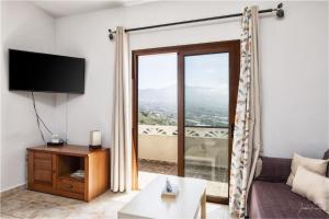 a living room with a tv and a large window at casa moni 2 in El Paso