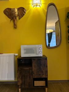 a microwave on a wooden table with a mirror at Le Bovary Hotel Suite Safari in Héron +14 photos
