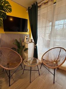 two chairs and two tables in a room with a window at Le Bovary Hotel Suite Safari in Héron