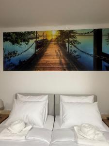 a white bed with a picture of a wooden bridge at Silver Hotel Budapest City Center in Budapest