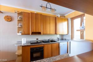 a kitchen with wooden cabinets and a white refrigerator at La Casetta di Pino in Varenna
