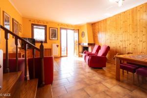 a living room with red chairs and a table at La Casetta di Pino in Varenna +26 photos