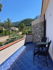 a patio with a table and chair on a balcony at Villa BellaVista in Belvedere Marittimo +40 photos