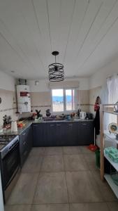 a large kitchen with blue cabinets and a window at El refugio de Marisela in Trevelín +9 photos
