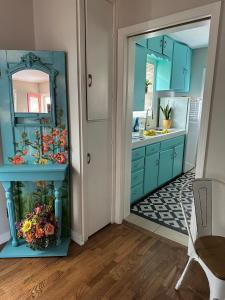 a bathroom with blue cabinets and a large mirror at Three Queens Entire House 3 Beds in Amarillo