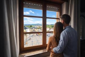 a man and a woman looking out of a window at Casa Rural Nito - Naturaleza y Descanso en Asturias in Villayón