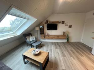 an attic living room with a table and a tv at Meeresbrise in Norden +6 photos