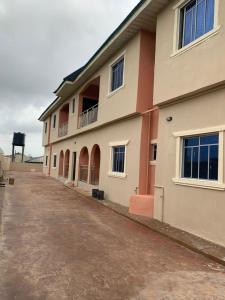 a building with a dirt road in front of it at Trendy Terrace in Benin City +8 photos