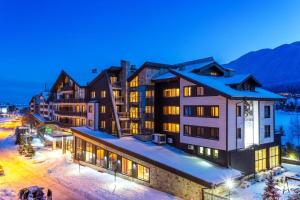 a group of buildings in the snow at night at Apartments Terra Harmony - 4 star free SPA resort, Golf i Skiing in Bansko