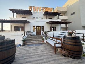 a house with a porch with a bench and stairs at Kissamos Bay Hotel in Kissamos