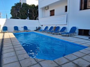 a swimming pool with chairs and a building at Kissamos Bay Hotel in Kissamos