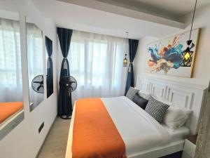 a bedroom with an orange and white bed and a window at Padmore residence-Kilimani in Gatunga