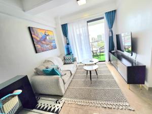a living room with a couch and a tv at Padmore residence-Kilimani in Gatunga