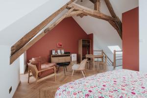 a bedroom with a bed and a desk and chairs at Les Cabottes in Change +49 photos