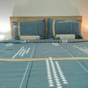 a bed with a blue comforter and pillows at SokoSTAR Apartman in Soko Banja