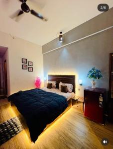 a bedroom with a large bed with a blue blanket at Ocean Bloomz Stay in Greater Noida