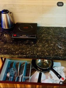 a kitchen counter with a stove and a pan on it at Ocean Bloomz Stay in Greater Noida
