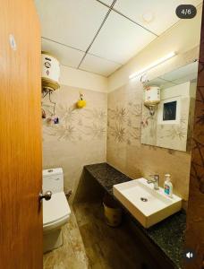 a bathroom with a sink and a toilet and a mirror at Ocean Bloomz Stay in Greater Noida