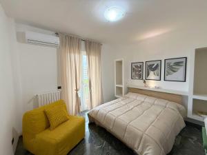 a bedroom with a bed and a yellow chair at Vista Mare 22 Due Camere triple o doppie in Bari