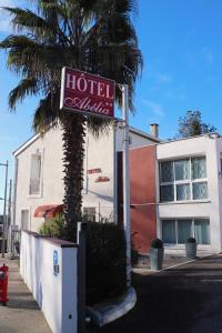 ein Hotelschild vor einer Palme in der Unterkunft Hotel Abelia in Montpellier
