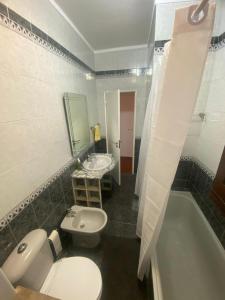 a bathroom with a toilet and a sink and a tub at Centro Da Vila in Lourinhã +6 photos