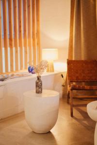 a room with a table with a vase with flowers in it at Hôtel Dune Saint-Pierre in Saint-Pierre-Quiberon
