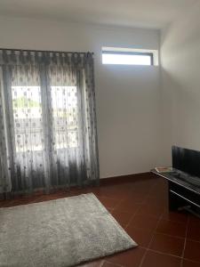 a living room with a window and a rug at Centro Da Vila in Lourinhã