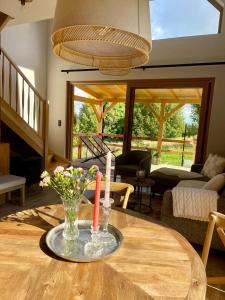 a table with two candles and a vase with flowers on it at Izera House in Świeradów-Zdrój