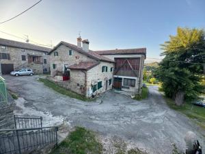 an old stone house with a car parked in a driveway at La corte dei celti 9 in Quinzano