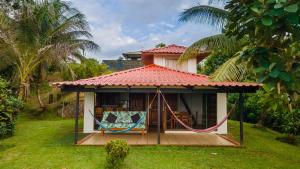 a small house with a hammock in the yard at Corcovado Green Cabin & House in Drake