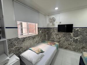 a small room with two beds and a window at Casa Hotel Manco Mora in Medellín