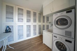 a white laundry room with a washer and dryer at Agriturismo Hegemone in Tremosine Sul Garda