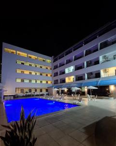a swimming pool in front of a hotel at night at Golden Beach Hotel in Fortaleza