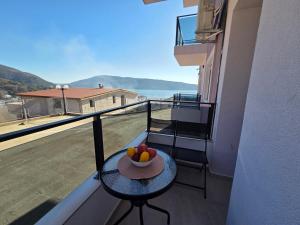 a bowl of fruit on a table on a balcony at Apartman Mimoza - Meljine in Meljine