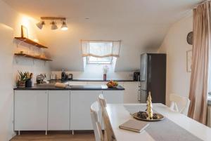 a kitchen with a table and a refrigerator at Dreiländer Blick Apartments in Lörrach +9 photos