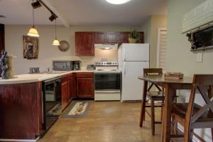 a kitchen with a white refrigerator and a table at Rivers Edge Condo 902 in Helen +5 photos